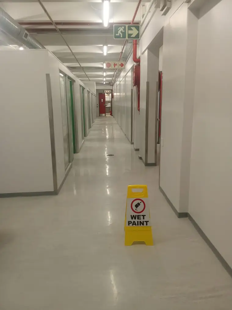 Commercial corridor freshly painted with a wet paint sign