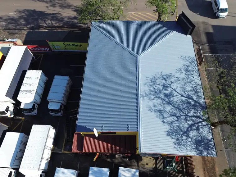 Whole warehouse with new roof sheeting and a yard of delivery trucks